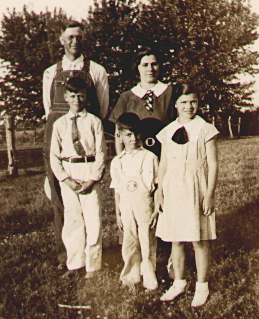 photographic portrait of John H. and Katie M. (Maun) Fiegenbaum family standing outside