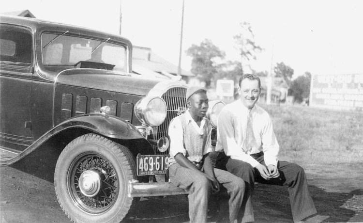 photo of Edward Hardin Lynch and an unidentified friend sitting on the front bumper of a 1930s car