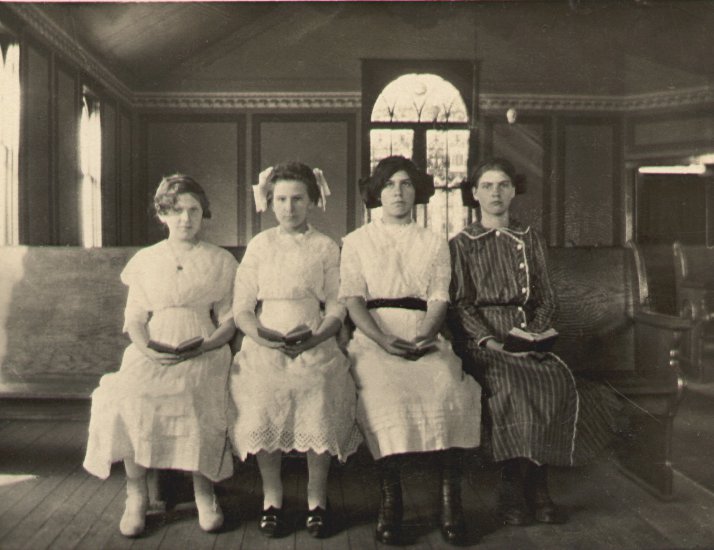 photograph of Katherine M. Maun's confirmation class, four very somber young women seated in the front pew of a small church